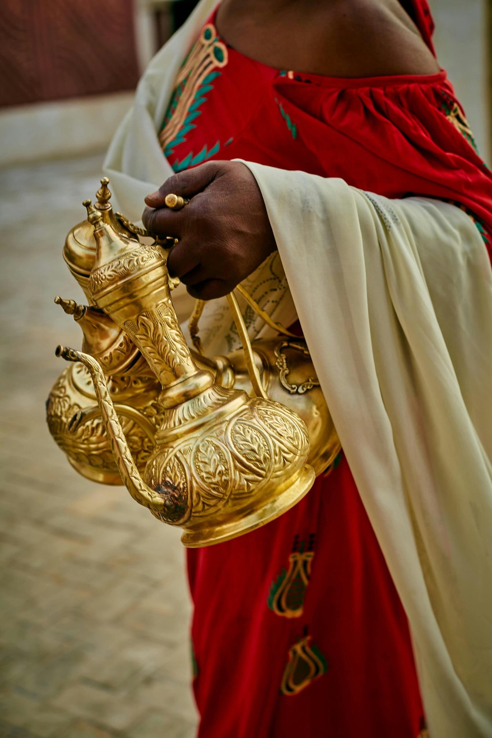 Close-up of ornate gold jugs in a traditional coffee ceremony setting.